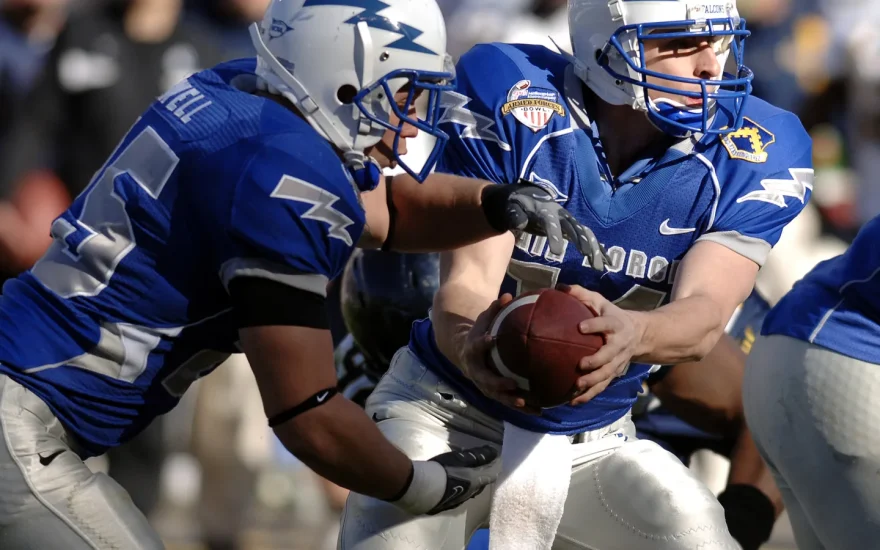 American football quarterback handing off the ball