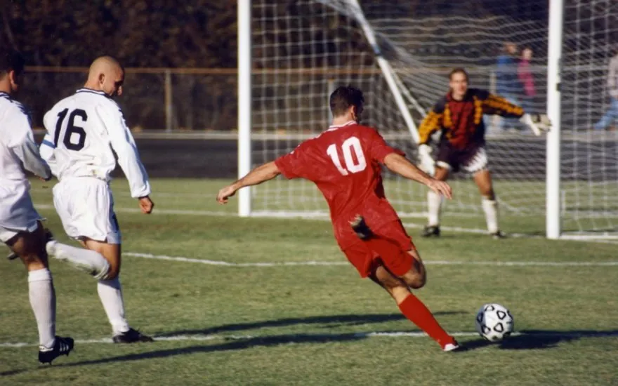 A football player striking a ball on a pitch, illustrating football analysis and handicaps